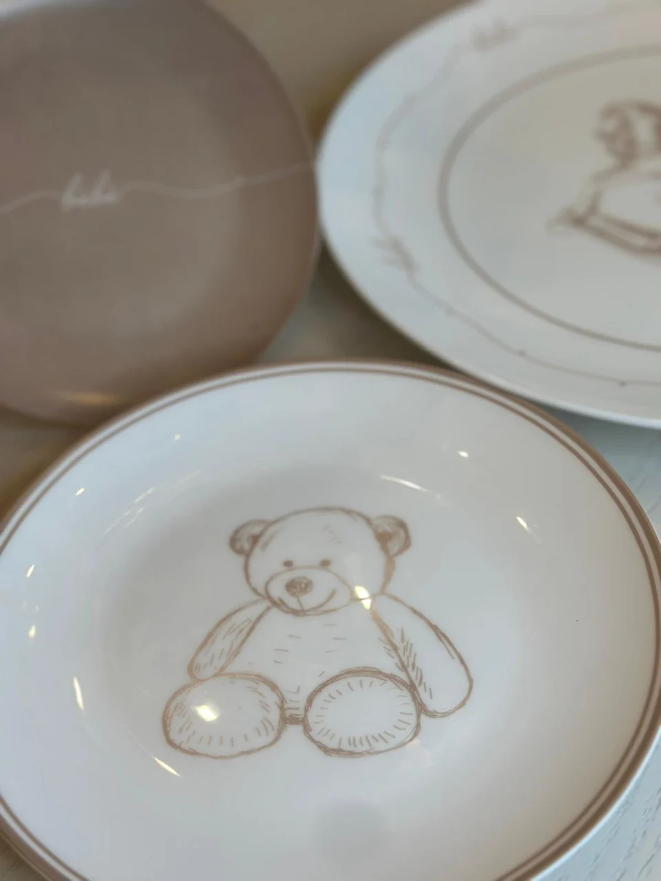 Close view of the teddy bear and rocking horse Bébé plates