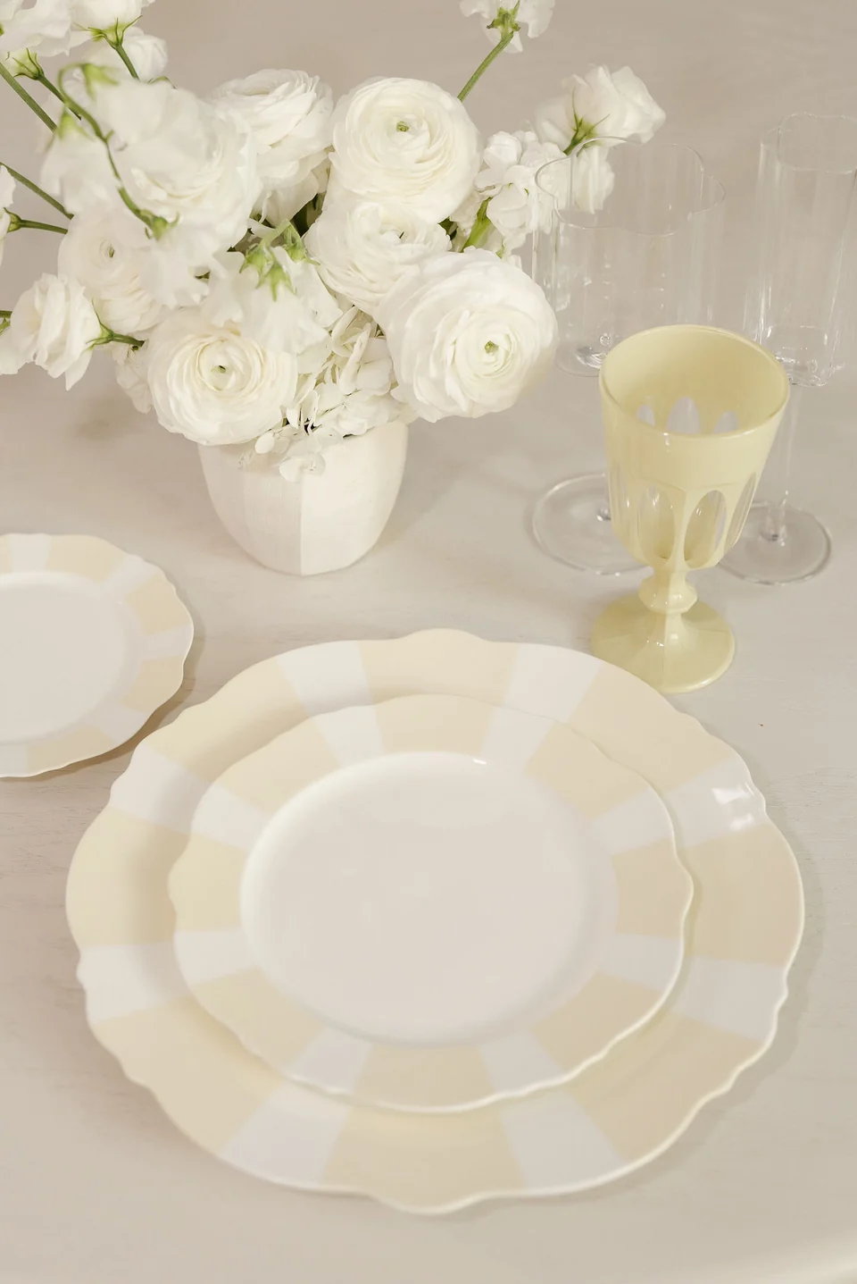 Butter-yellow and cream Sunny Stripe plates with white flowers and a yellow goblet